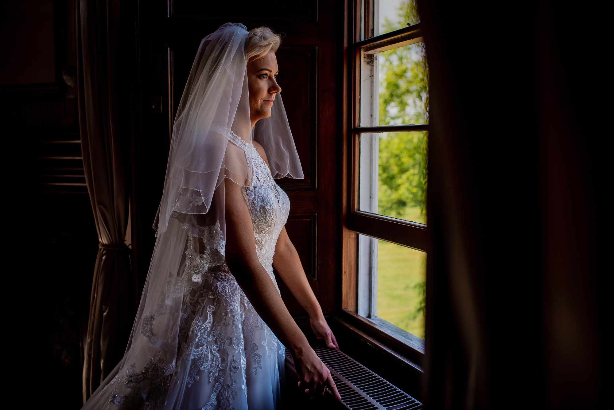 Bride looking out of the window at Hockwold Hall Wedding Venue