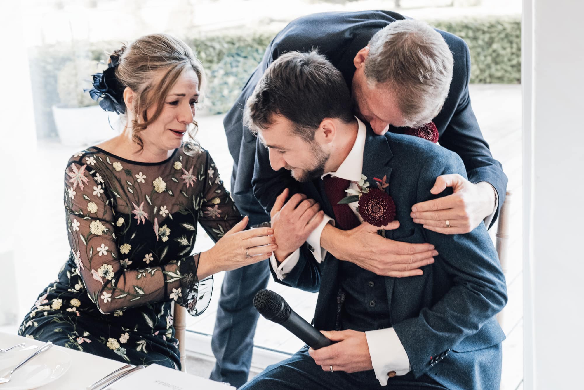 Emotional Family embrace during speeches at an Old Hall Ely Wedding