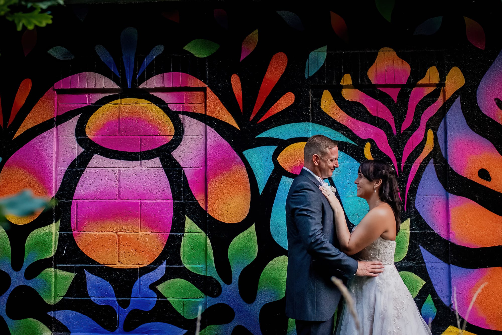 Wedding couple with colourful mural behind