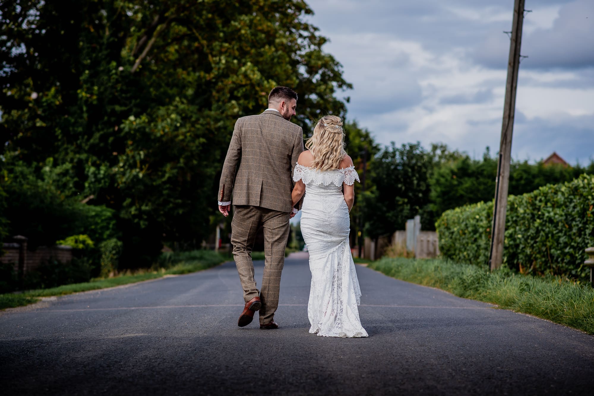Bride and groom walking away from area at Cambridgeshire home wedding