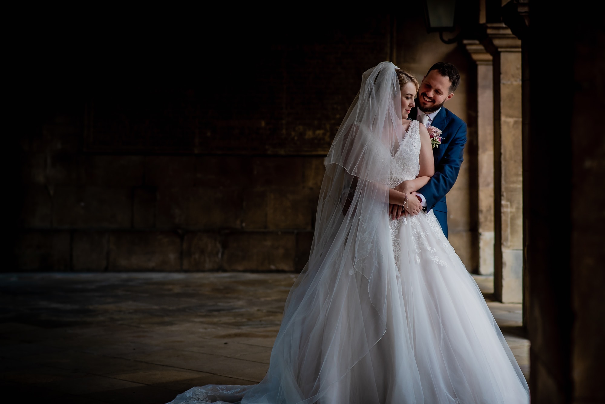 Bride and Groom under the arches at Emmanuel College in Cambridge