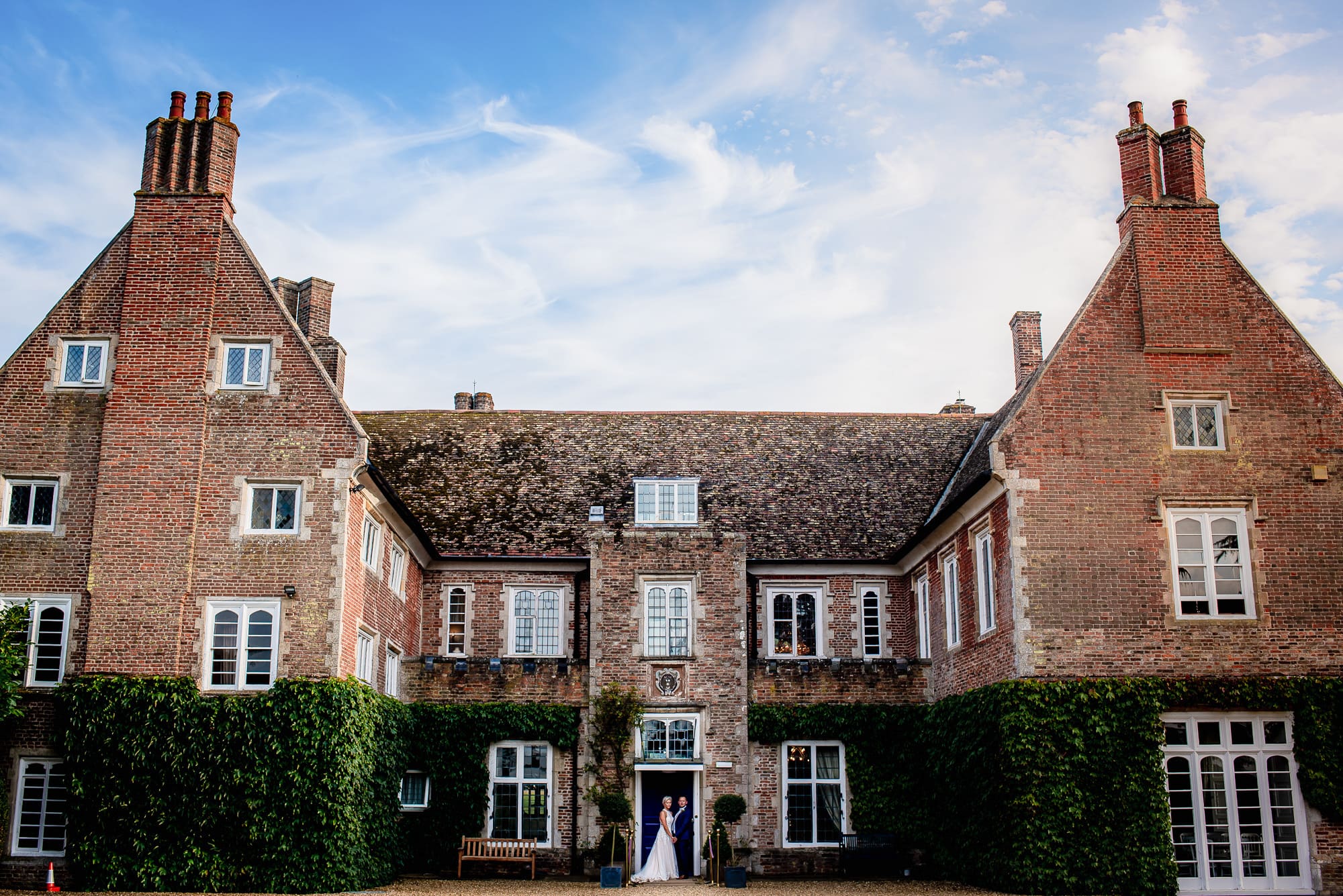 Bride & Groom at the front entrance of Hockwold Hall Wedding Venue in Norfolk