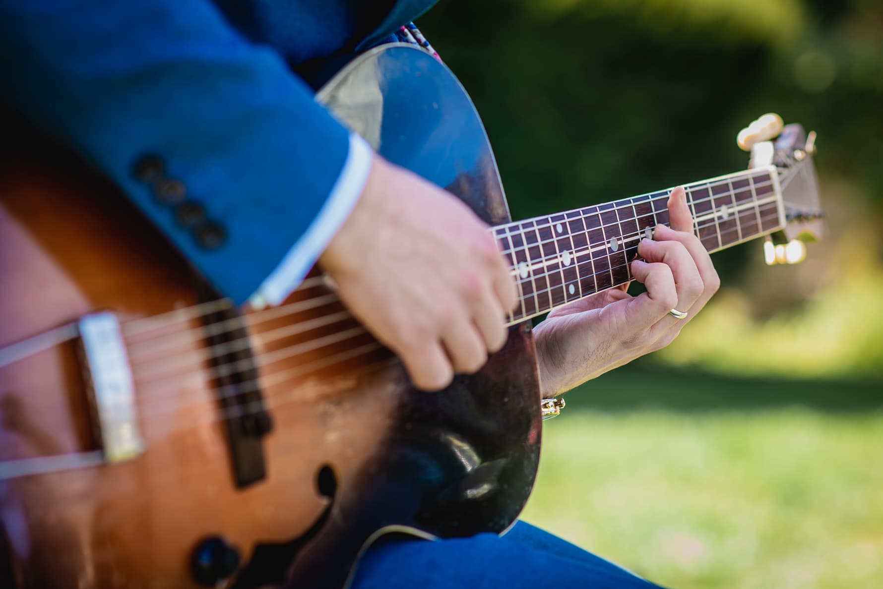 A guitarist playing a barre chord at a wedding reception.