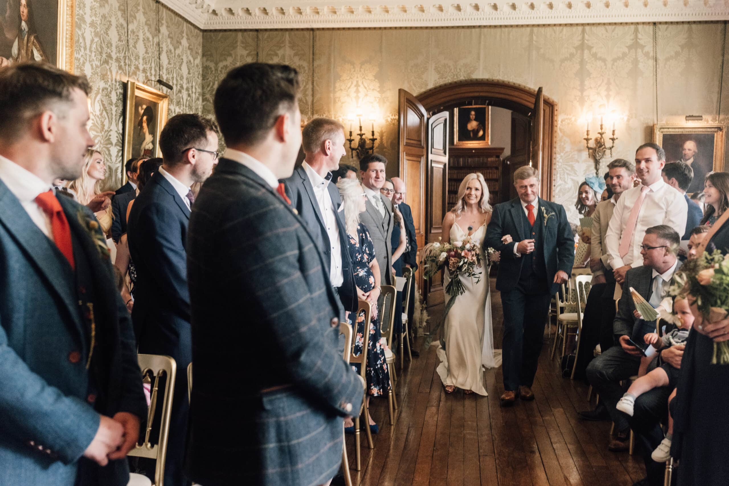 Bride enters her wedding ceremony at Holdenby House