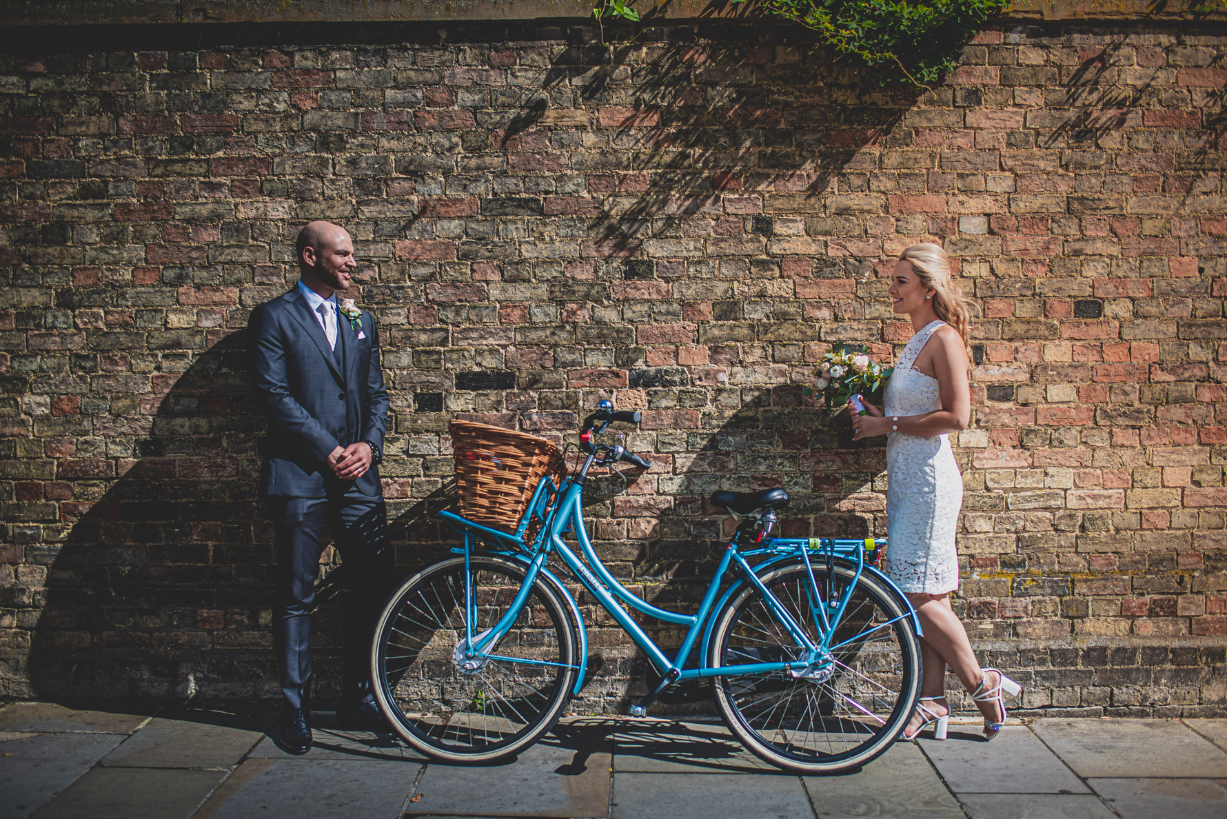 Bride & Groom by an old wall and bike in Cambridge
